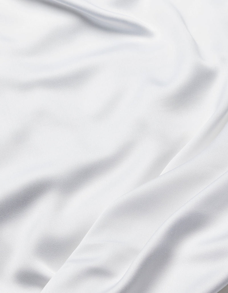 The Cozy Earth Bamboo Flat Sheet features smooth white fabric with soft folds and gentle waves, offering a silky and elegant texture.