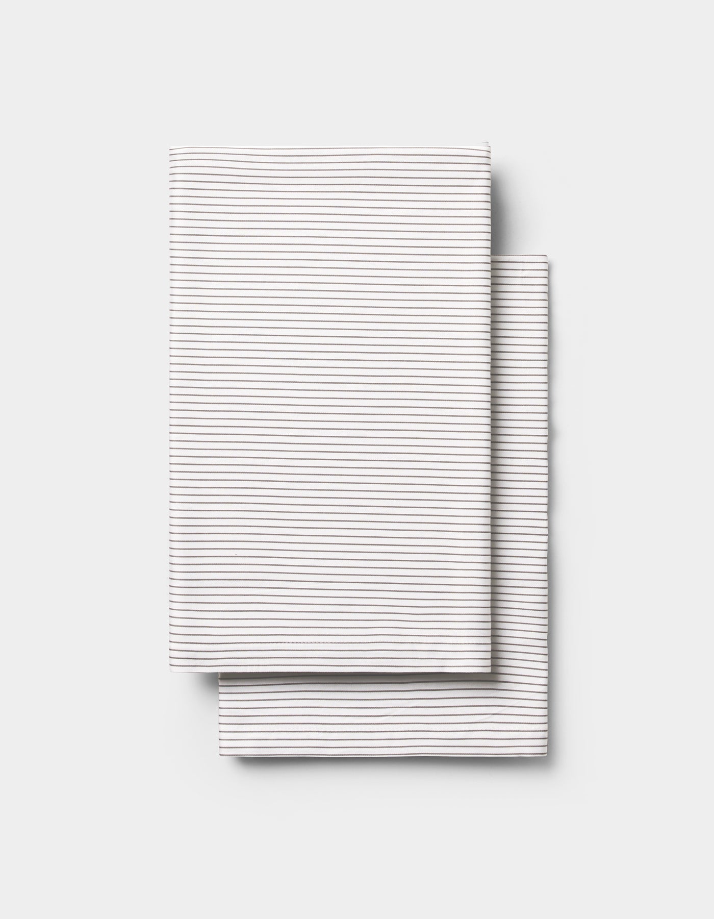 Two neatly folded Cozy Earth Bamboo Pillowcases, white with thin horizontal gray stripes, stacked on a plain light gray background.