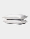 Two Cozy Earth Bamboo Pillowcases, in white with subtle thin gray stripes, are stacked together against a plain light gray background.|Color:Charcoal Pinstripe