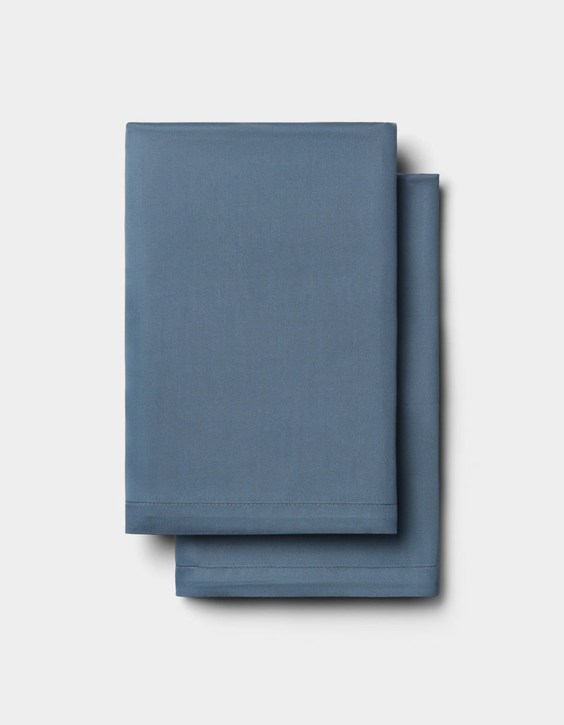 Two neatly folded Cozy Earth Bamboo Bedding Deluxe Bundle - Silk sheets are stacked atop each other against a plain white background.