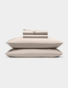 A neatly stacked Cozy Earth Bamboo Sheet Set, featuring two pillows, a folded fitted sheet, flat sheet, and pillowcases, displayed against a plain white background.|Color:Driftwood