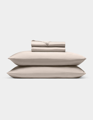 A neatly stacked Cozy Earth Bamboo Sheet Set, featuring two pillows, a folded fitted sheet, flat sheet, and pillowcases, displayed against a plain white background.|Color:Driftwood