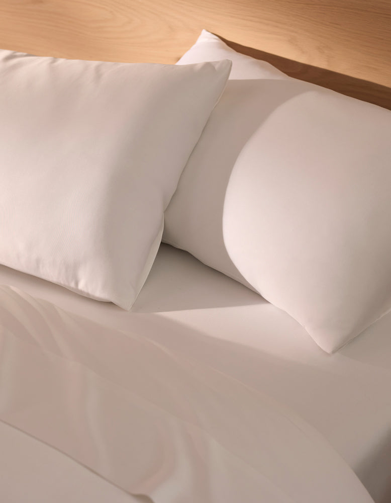 Close-up of white pillows on a bed with white Cozy Earth Bamboo bedding.