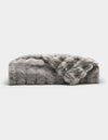 The Bubble Cuddle Blanket by Cozy Earth is a plush, light gray faux fur throw with a soft, textured surface, shown folded and partially draped open against a plain white background.|Color:Light Grey