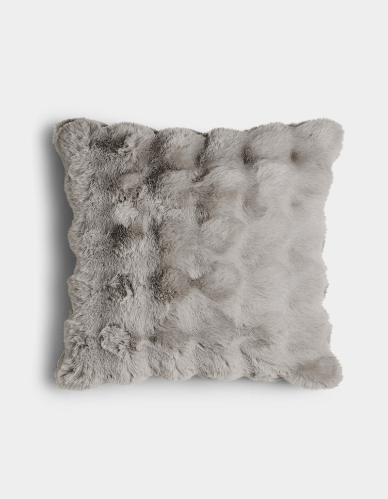 The Bubble Cuddle Pillow by Cozy Earth is a square, light gray faux fur cushion with a fluffy, textured surface, shown from above on a plain white background.