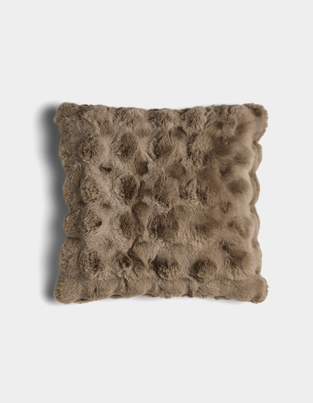 The Bubble Cuddle Pillow by Cozy Earth is a square, brown faux fur pillow with a textured, tufted surface, shown against a white background.