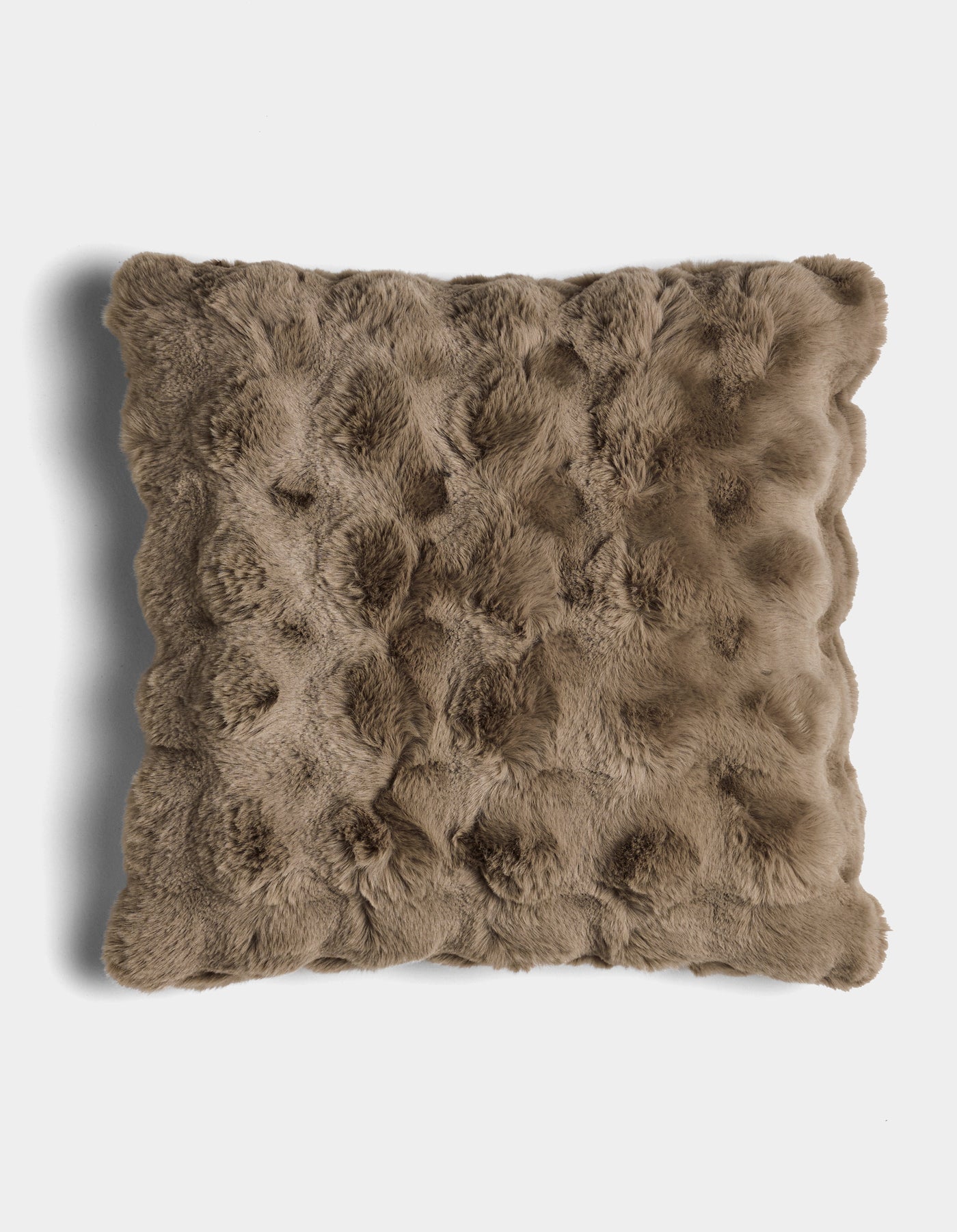 The Bubble Cuddle Pillow by Cozy Earth is a square, brown faux fur pillow with a textured, tufted surface, shown against a white background.