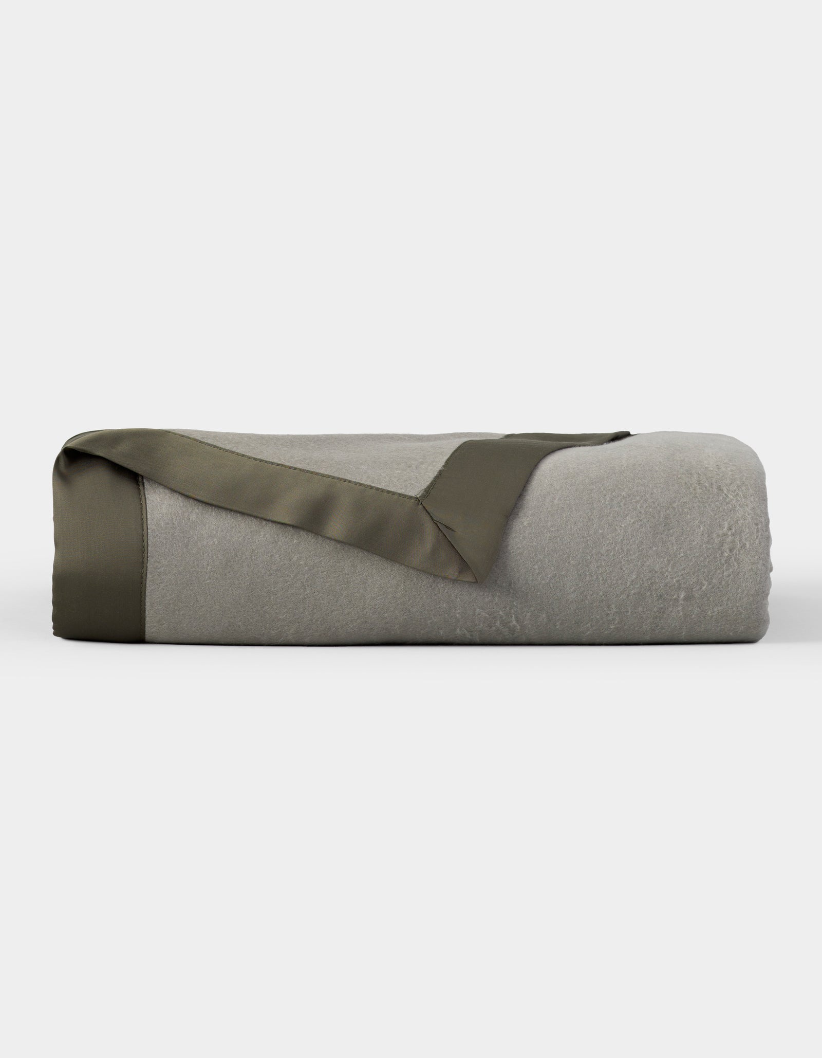 The Cozy Earth Bamboo Blanket, shown neatly folded with an olive green satin trim, is featured against a plain white background. 