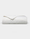 The Bamboo Viscose All Season Comforter by Cozy Earth, featuring a neatly folded white design with a subtle sheen, is displayed against a plain light background.