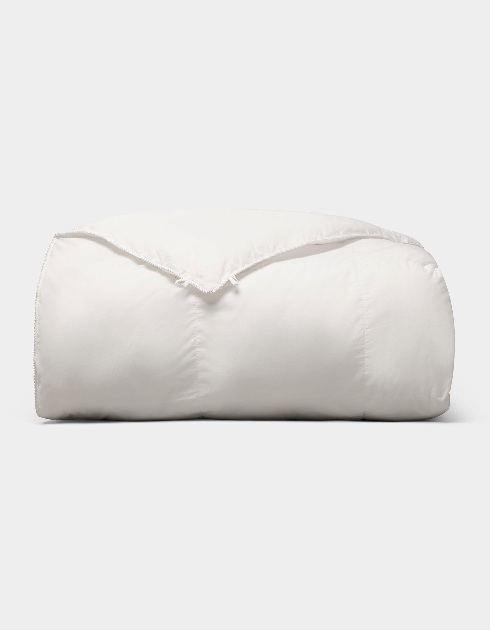 The Cozy Earth Down Alternative Comforter is neatly folded and fluffy, displayed against a plain light gray background. 