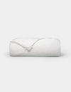 The Cozy Earth Silk Comforter is neatly folded with a corner turned down, showcased against a plain white background.
