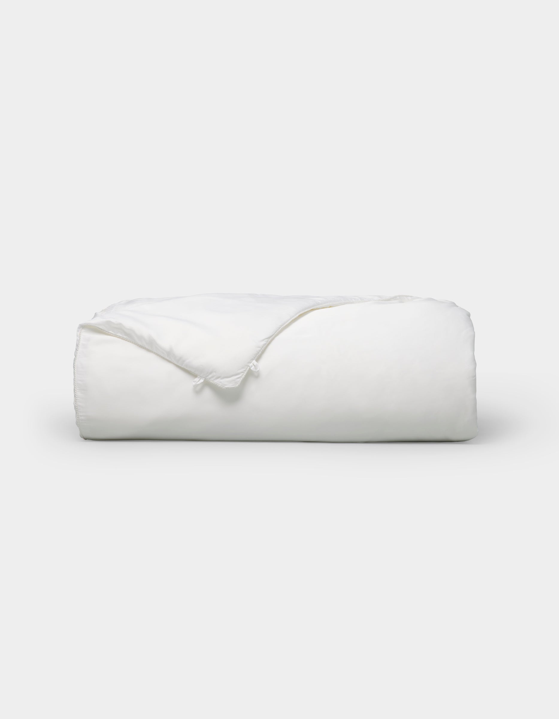 The Cozy Earth Silk Comforter is neatly folded with a corner turned down, showcased against a plain white background.