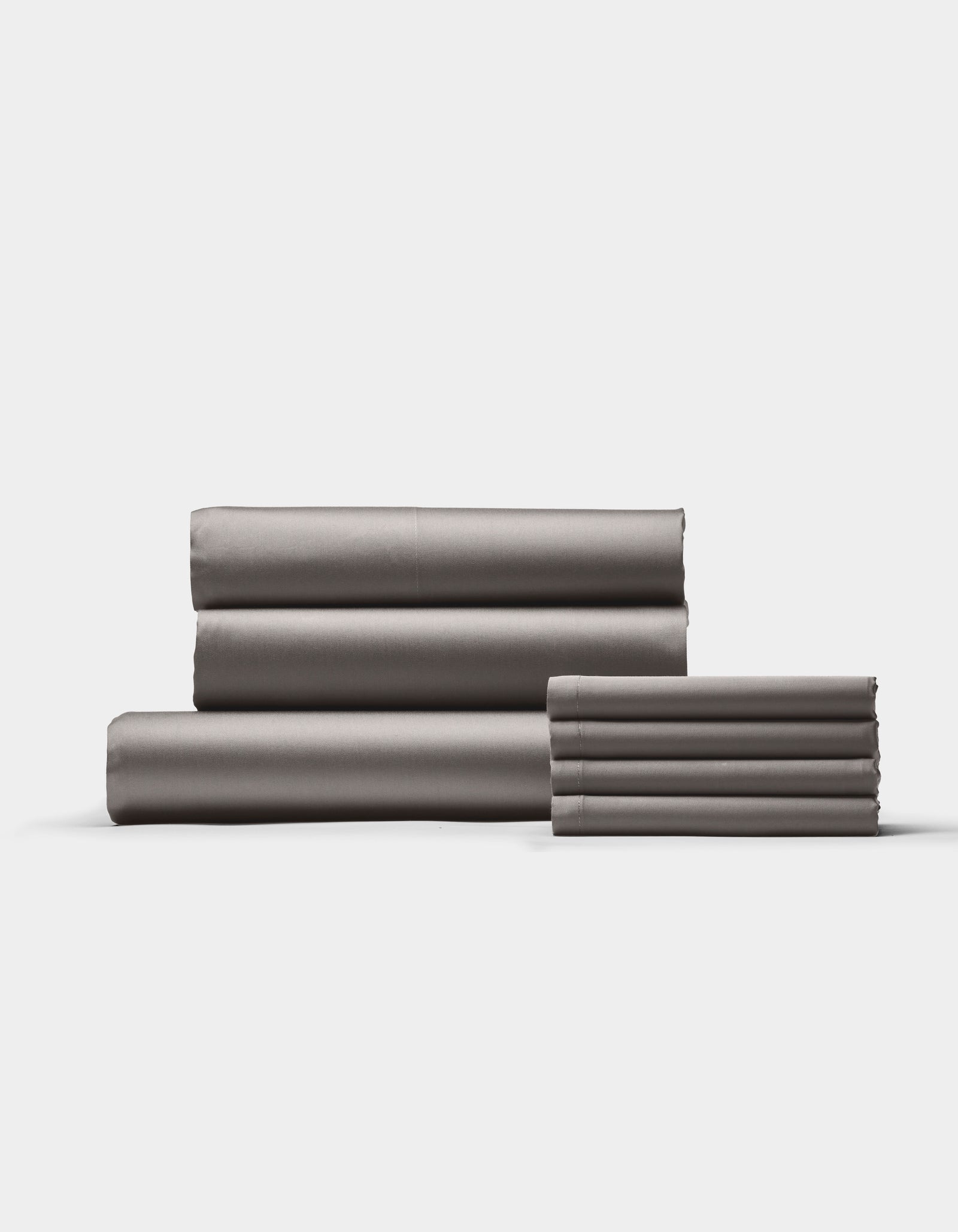 The Cozy Earth Bamboo Bedding Core Bundle features neatly folded gray bed sheets arranged in two stacks against a plain white background.