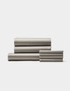 A neatly folded stack of Cozy Earth Bamboo Bedding Core Bundle bed sheets and pillowcases arranged side by side on a plain white background.|Color:Dove Grey