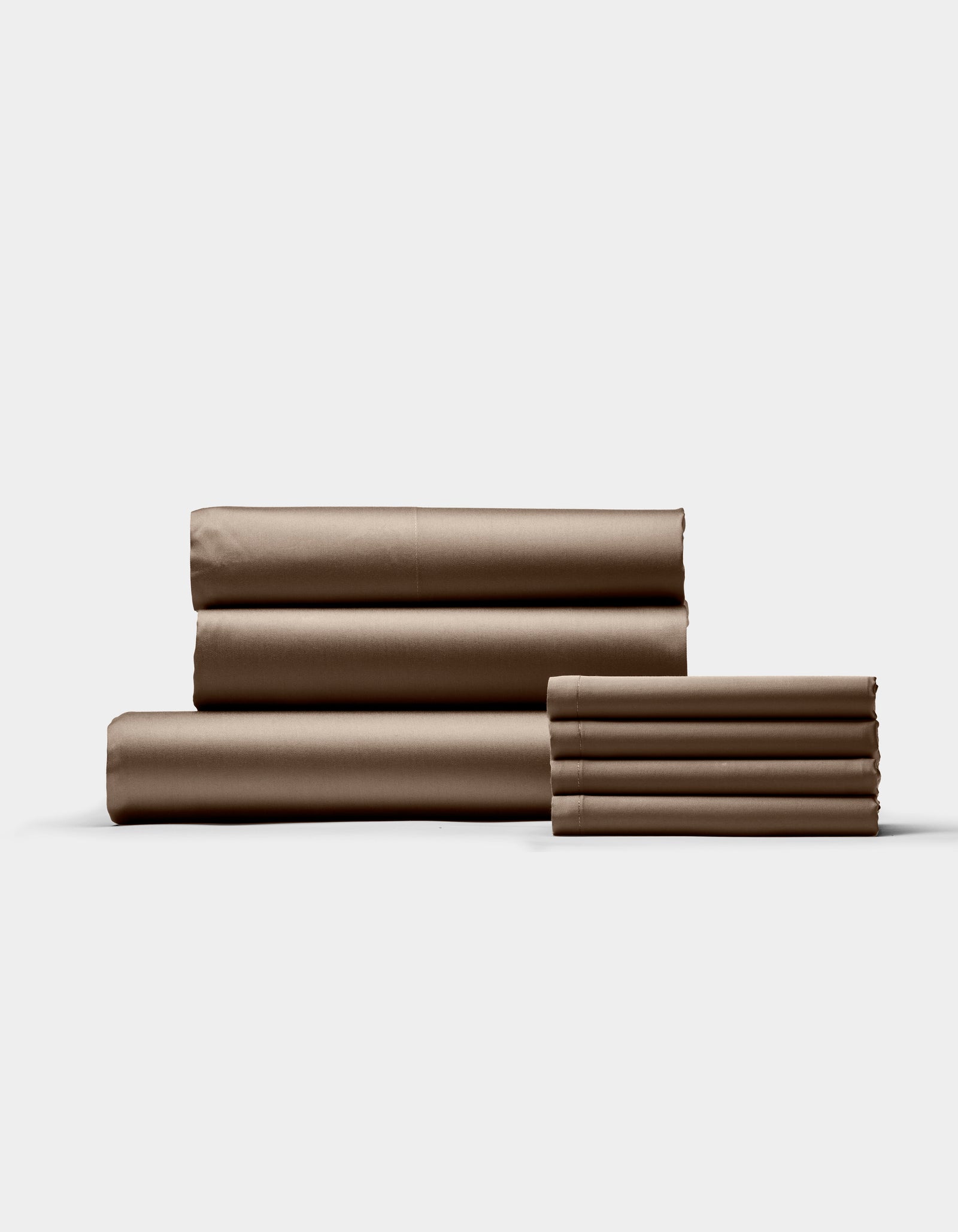 The Cozy Earth Bamboo Bedding Core Bundle is shown neatly stacked on a light background, featuring brown bed sheets and pillowcases—both large and small pieces are folded and displayed side by side.