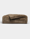 The Cozy Earth Cuddle Blanket, featuring a plush brown fabric and soft, fuzzy texture, is shown folded against a plain white background.|Color:Walnut