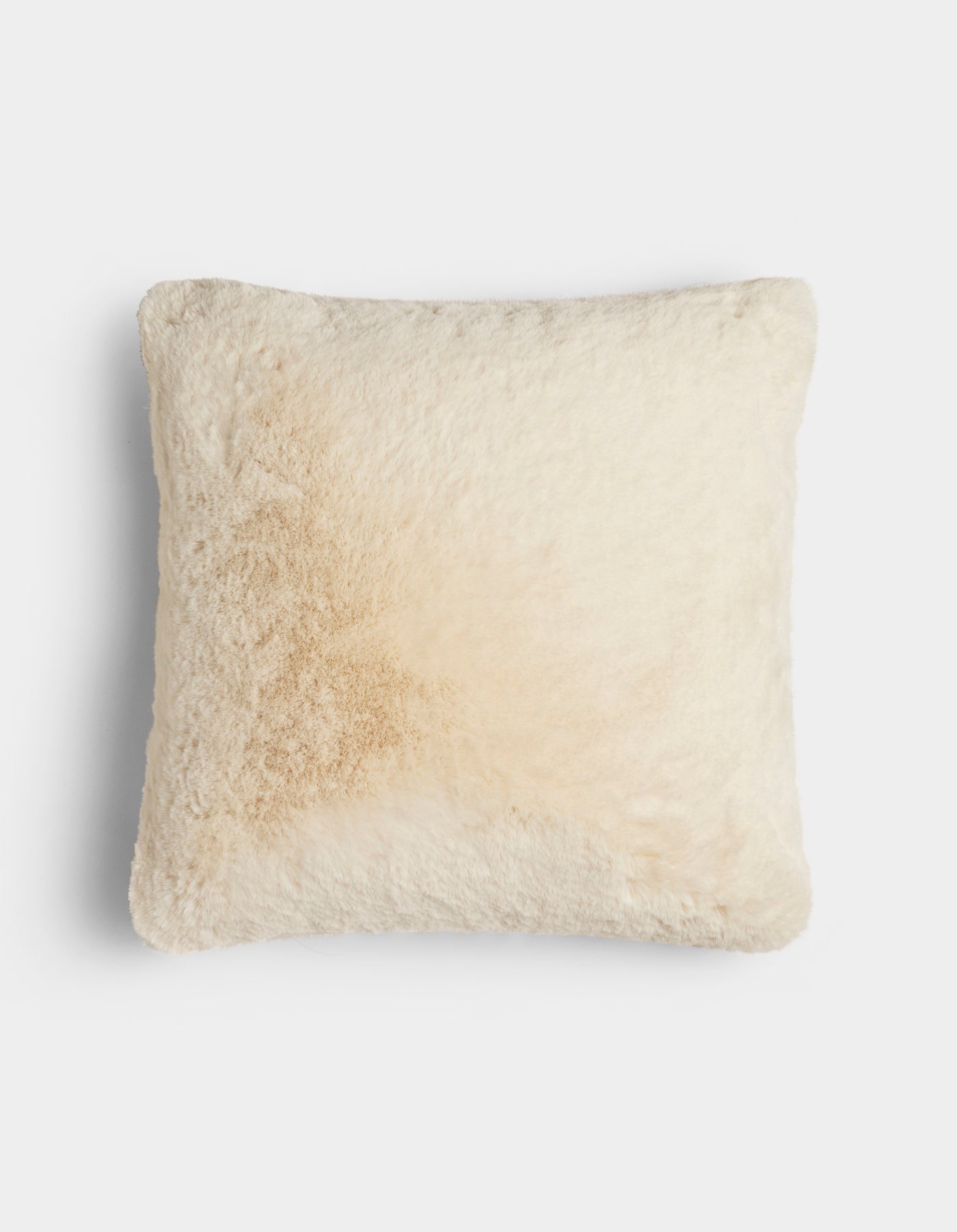 The Cuddle Pillow by Cozy Earth is a square, cream-colored, fluffy pillow featuring a light tan stain on the left side, shown against a plain white background.