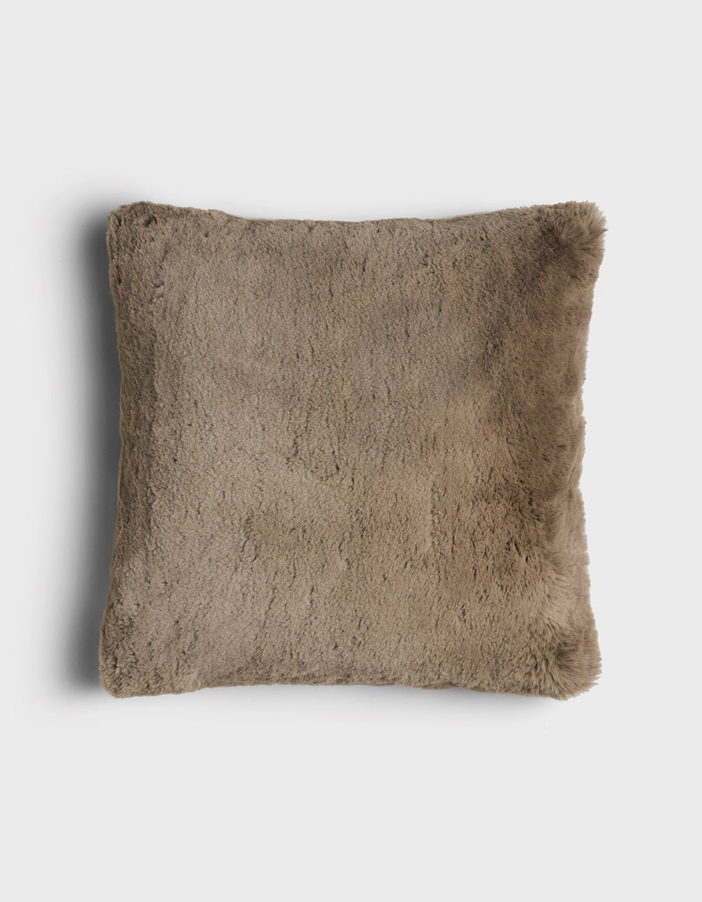 The Cuddle Pillow by Cozy Earth is a square, brown faux fur pillow with a soft, fluffy texture, displayed on a plain white background.