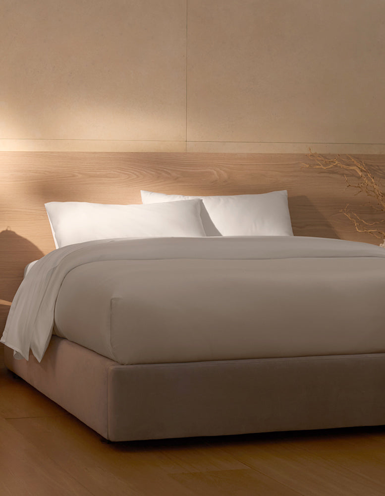 White Cozy Earth Bamboo Sheet set on a bed with wooden headboard