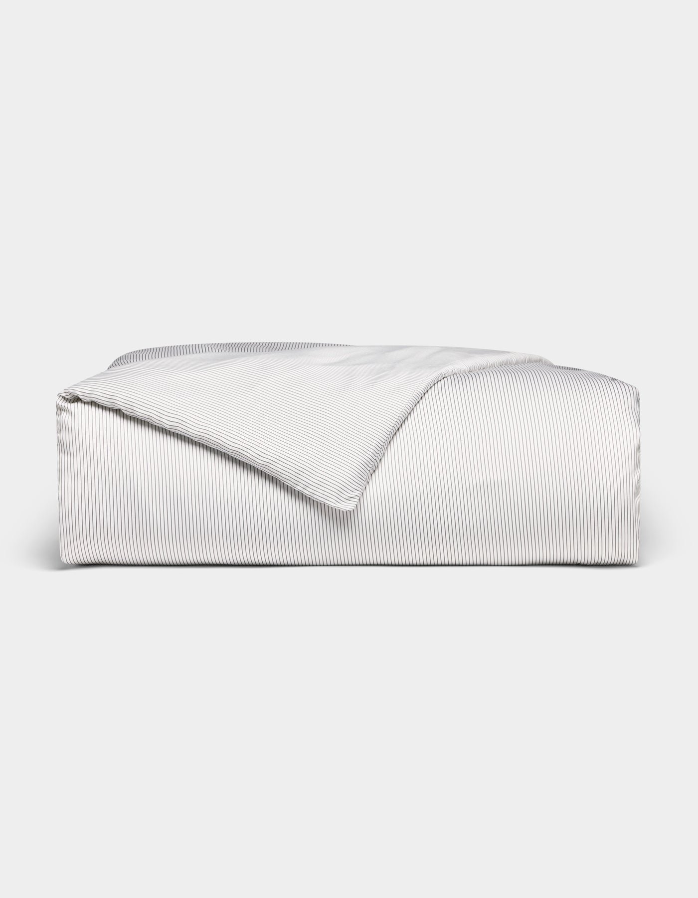 The Bamboo Duvet Cover by Cozy Earth, shown neatly folded with a corner flipped over, features white and gray pinstripes and is displayed against a plain white background.
