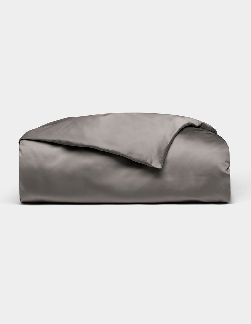 A neatly folded, shiny gray Bamboo Duvet Cover by Cozy Earth is displayed on a plain white background.