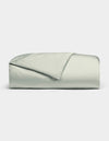 A neatly folded Bamboo Duvet Cover by Cozy Earth in light gray or pale green, with one corner flipped to reveal the interior, set against a plain white background.|Color:Laurel