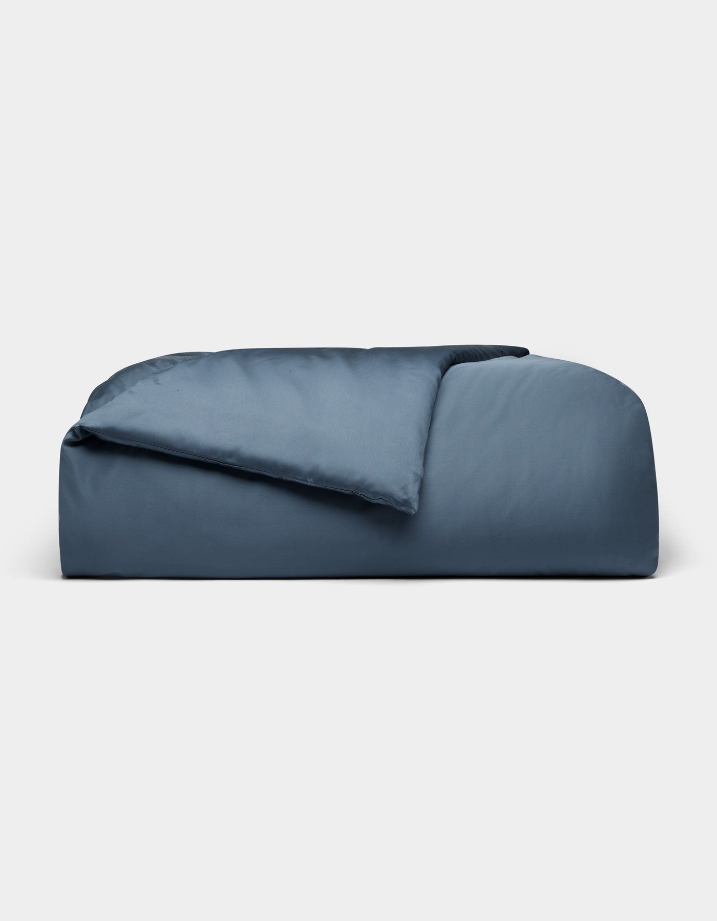 The Cozy Earth Bamboo Duvet Cover, in dark blue and rectangular shape, features plush fabric with a partially folded comforter, displayed against a plain light gray background.