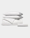 The Bamboo Bedding Essential Bundle by Cozy Earth features a white set with thin gray pinstripes—two pillows, a duvet cover, and a fitted sheet—neatly folded and displayed against a plain white background. |Color:Charcoal Pinstripe