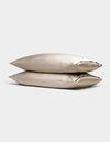 Two Cozy Earth Bamboo Pillowcases in beige are stacked together against a simple light gray background.|Color:Driftwood