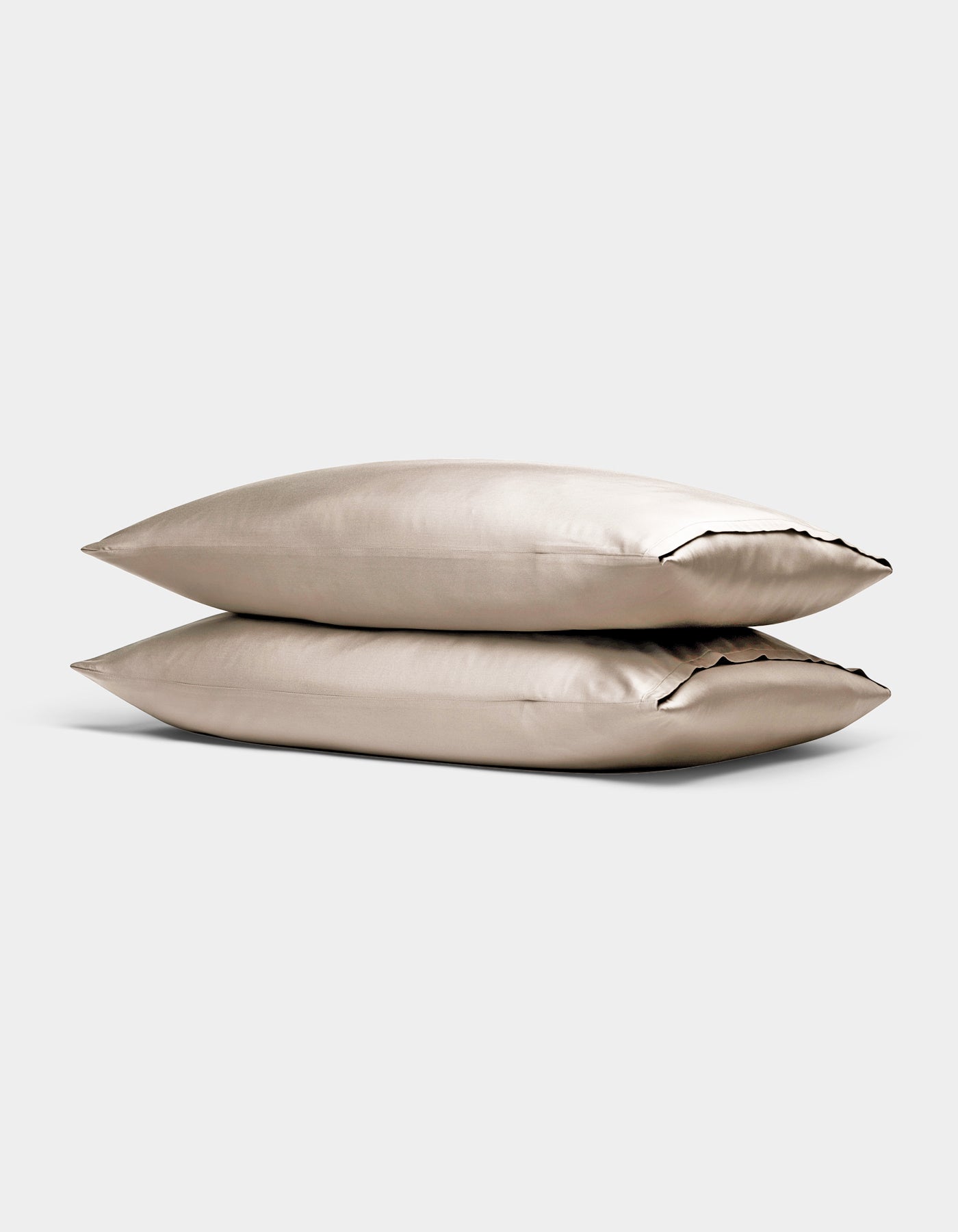 Two Cozy Earth Bamboo Pillowcases in beige are stacked together against a simple light gray background.
