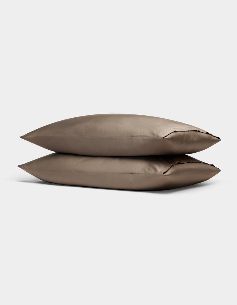 Two Cozy Earth Bamboo Pillowcases in taupe, rectangular and neatly stacked on top of each other, are displayed against a plain light gray background.