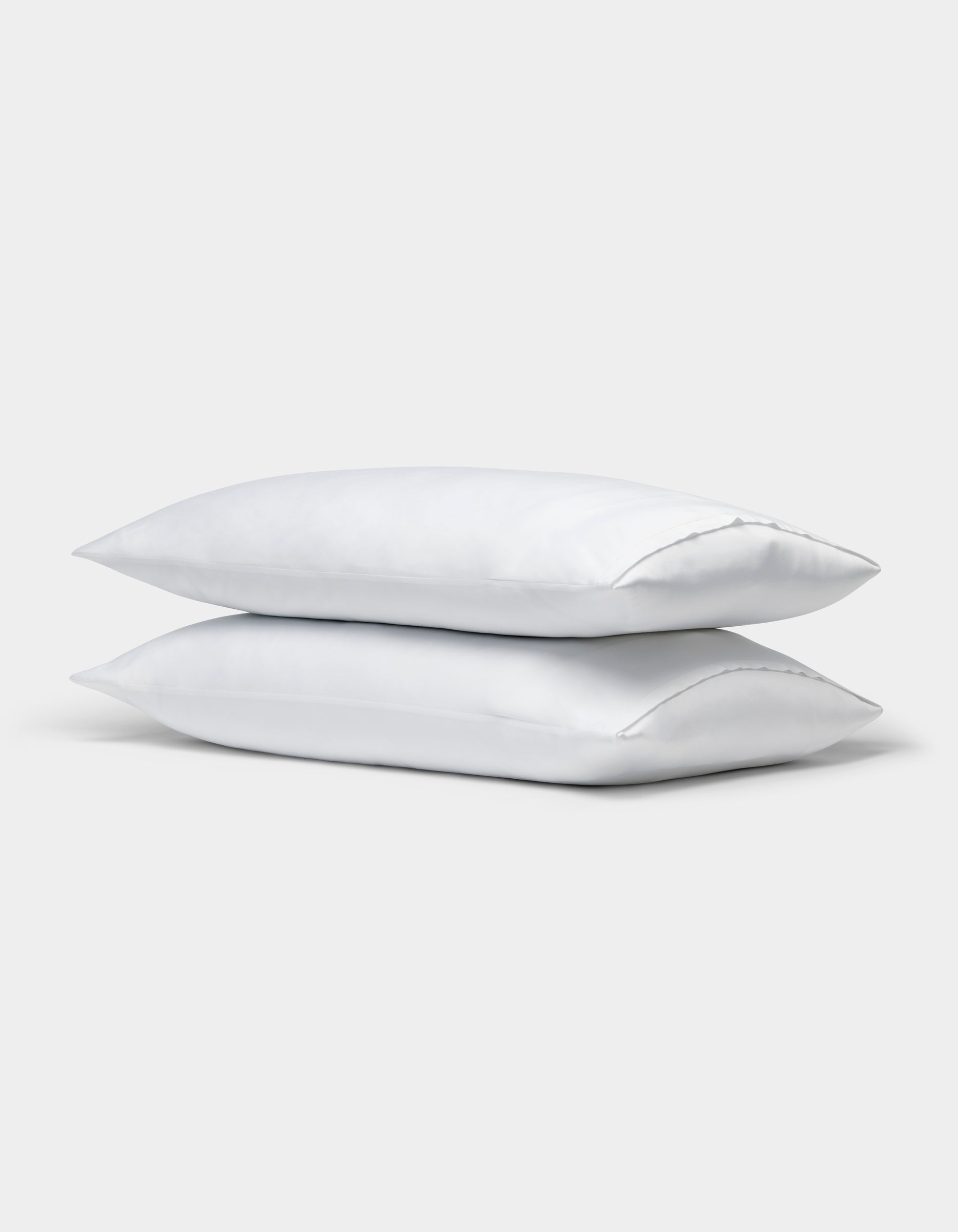Two Cozy Earth Bamboo Pillowcases in white are stacked together against a plain light gray background.