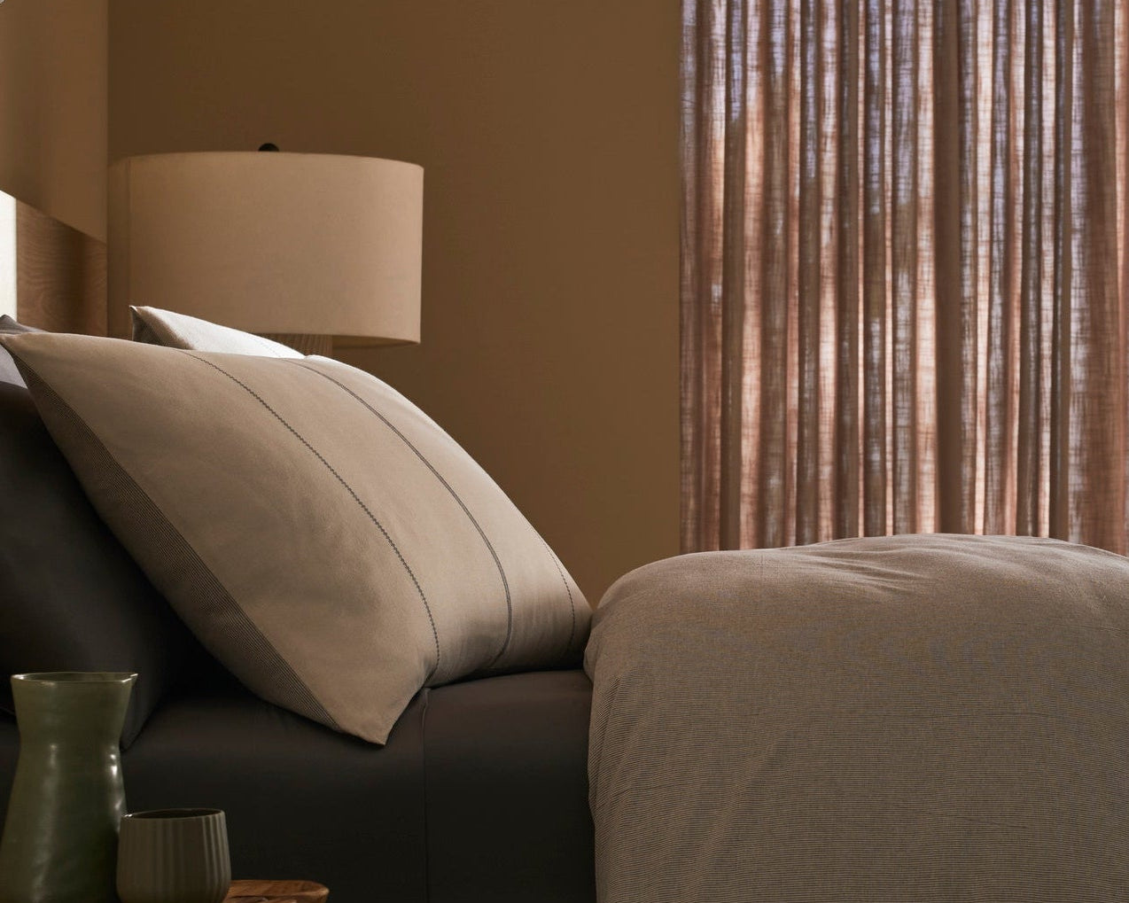 Modern bedroom with a bed and ocean view through a window.