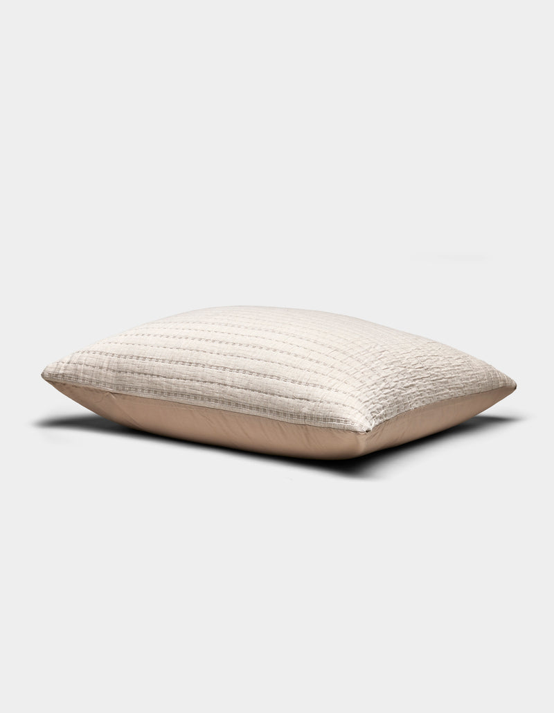 The Baja Matelasse Sham by Cozy Earth is a beige, rectangular pillow sham featuring a textured, quilted design, shown on a plain white background.