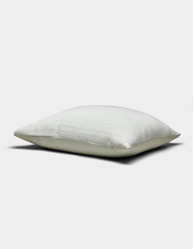 The Baja Matelasse Sham by Cozy Earth, shown in white with a smooth, subtly textured surface, is displayed horizontally against a plain light gray background.