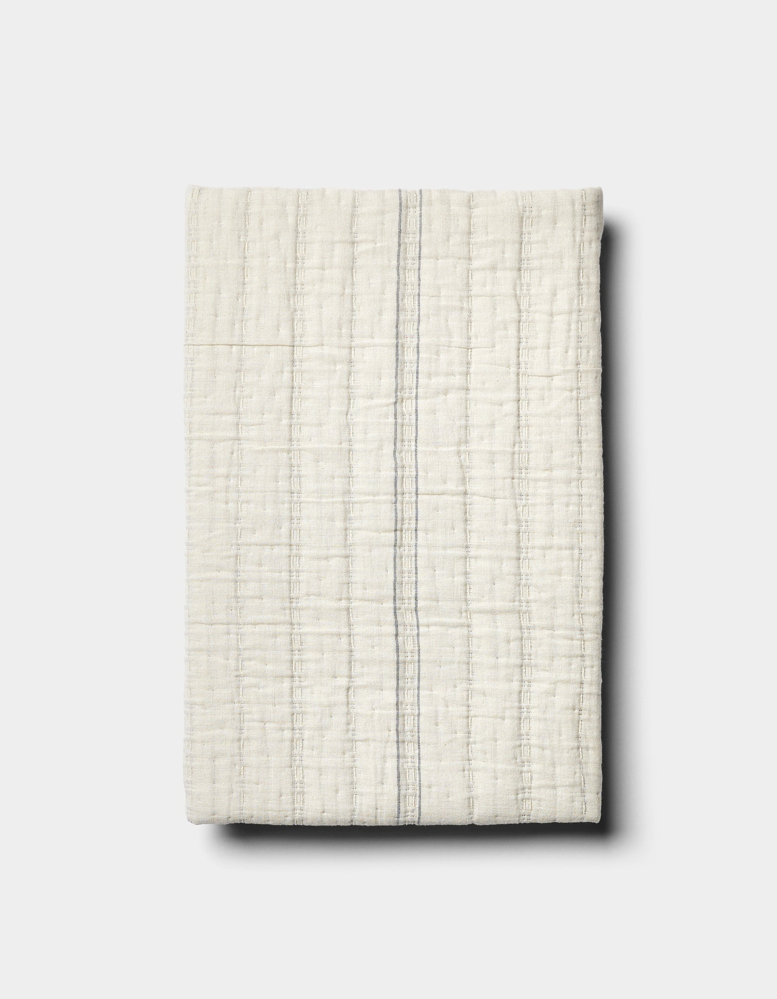 The Baja Matelasse Sham by Cozy Earth features off-white textured fabric with a subtle grid pattern and a single thin grey vertical stripe, displayed on a light grey background.