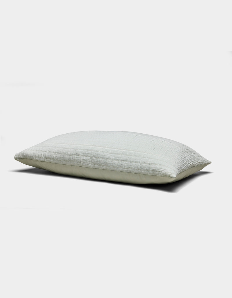 The Baja Matelasse Sham by Cozy Earth is a light-colored, rectangular pillow sham with a soft, textured surface. Displayed against a white background, it looks plush and comfortable.