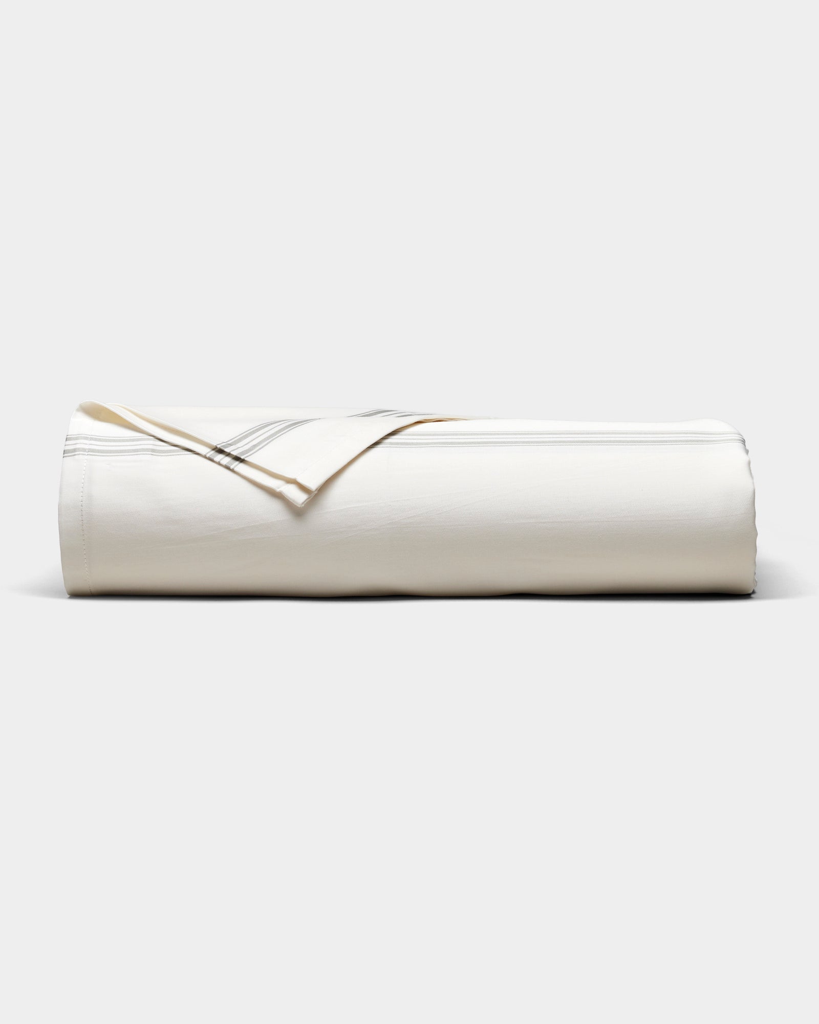 The Cozy Earth Bamboo Sheet Set, in cream with subtle gray stripes, is neatly rolled and displayed on a plain white background.