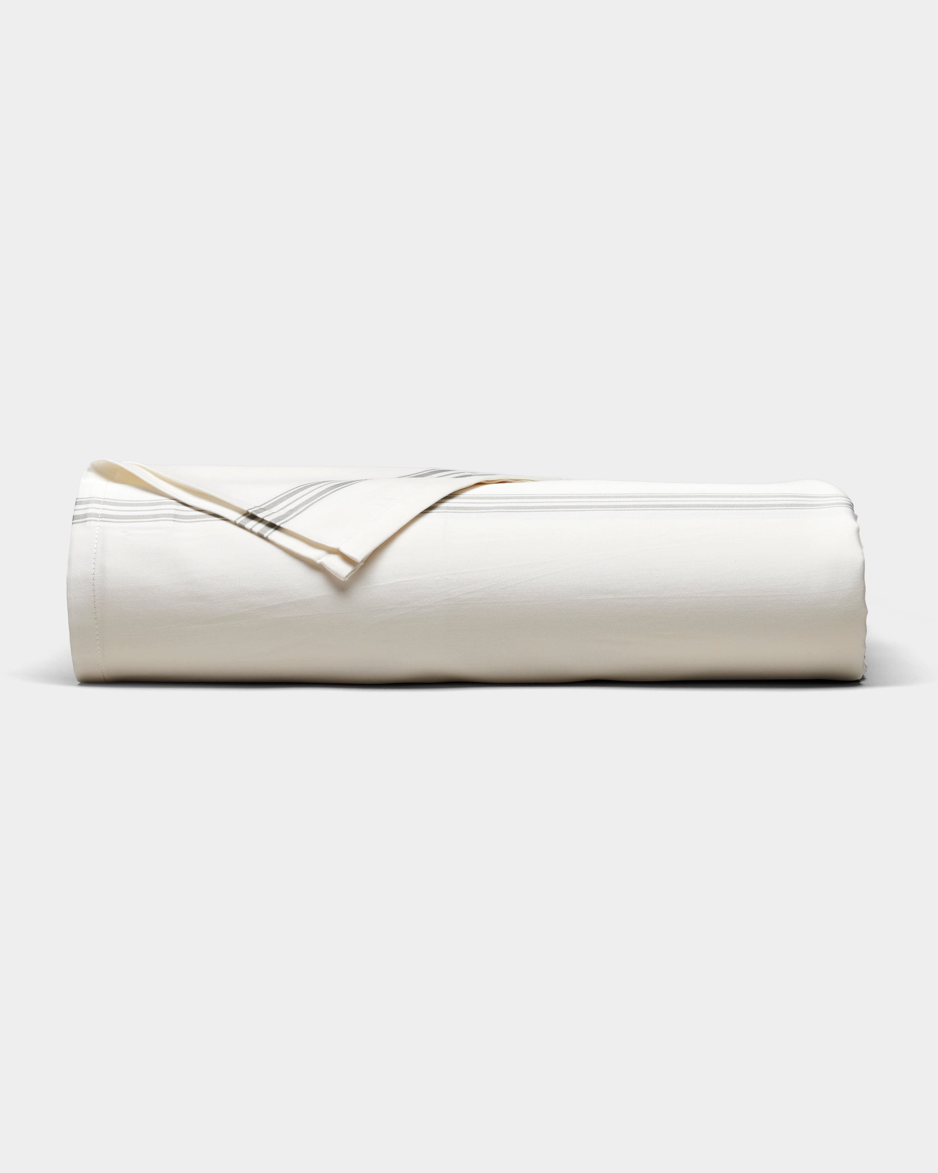 The Cozy Earth Bamboo Sheet Set, in cream with subtle gray stripes, is neatly rolled and displayed on a plain white background.