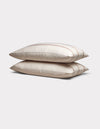 Two Cozy Earth Bamboo Pillowcases in cream with subtle brown stripes are stacked neatly on a plain light gray background.|Color:Baja Stripe in Maple
