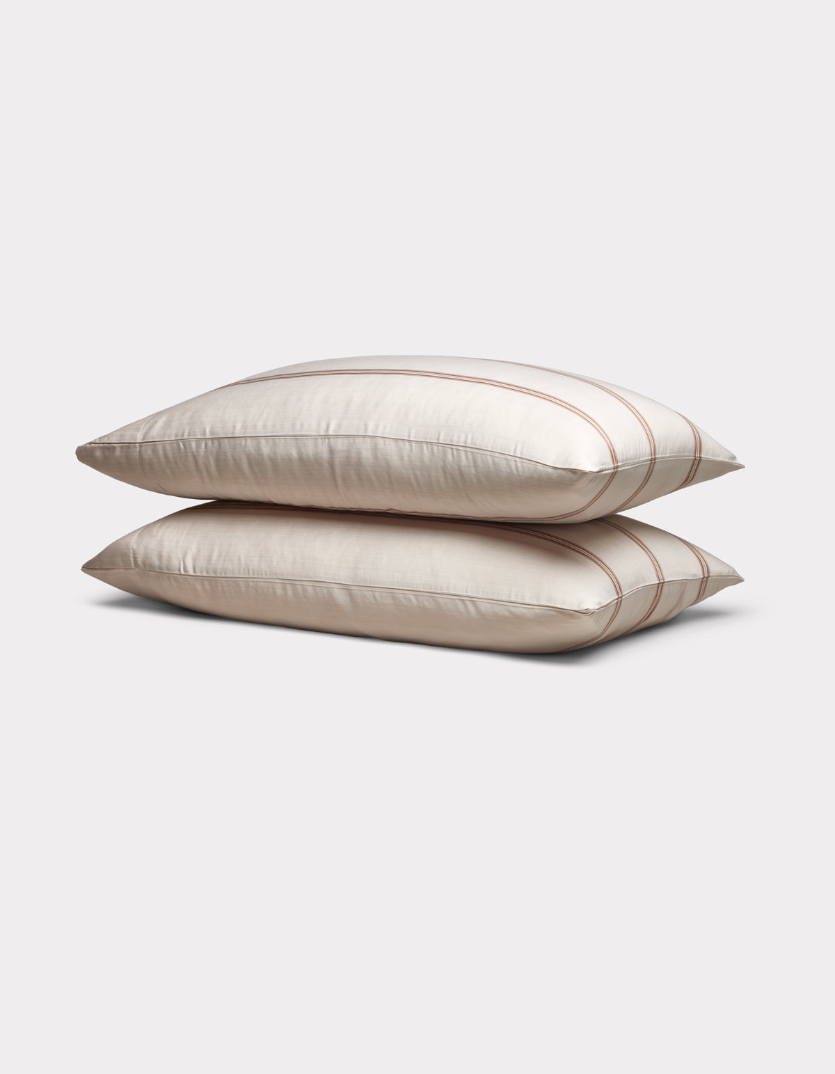 Two Cozy Earth Bamboo Pillowcases in cream with subtle brown stripes are stacked neatly on a plain light gray background.