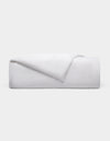 The Cozy Earth Linen Duvet Cover, neatly folded with one corner turned down, is displayed against a plain light gray background.