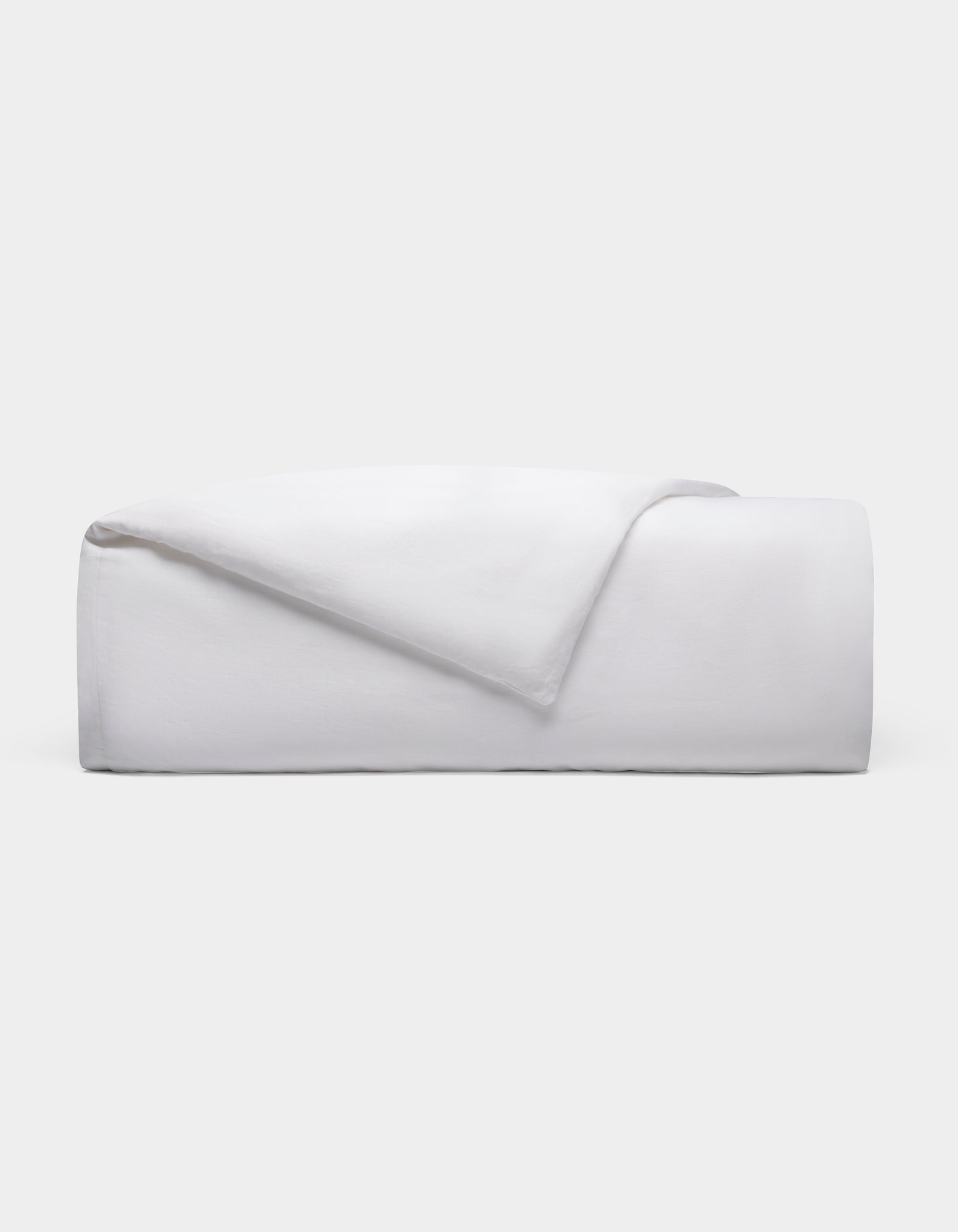The Cozy Earth Linen Duvet Cover, neatly folded with one corner turned down, is displayed against a plain light gray background.