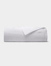 The Cozy Earth Linen Quilt, featuring a smooth texture, is neatly folded and displayed against a plain light gray background.|Color:White