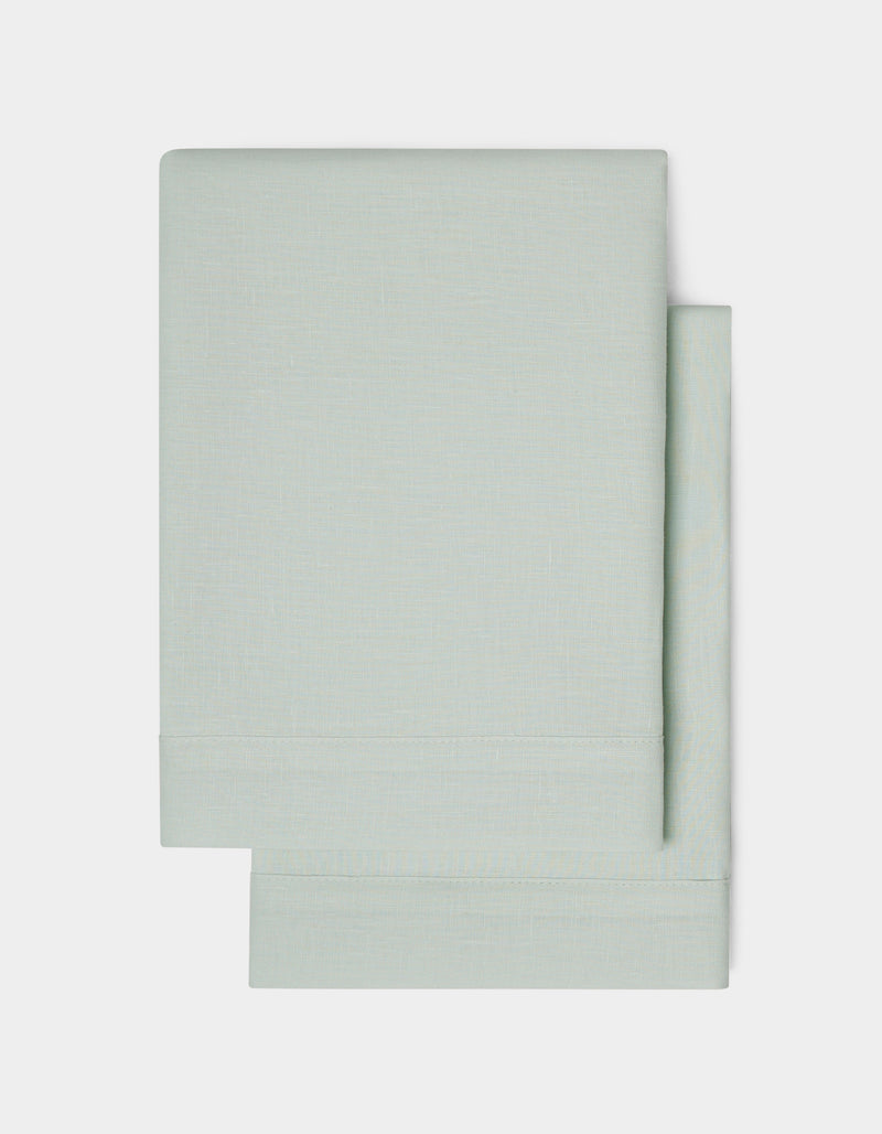 Two neatly folded Linen Shams by Cozy Earth in light gray are stacked on a plain white background, highlighting their simple and clean design.