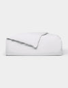 The Cozy Earth Soft-Wash Cotton Duvet Cover, in white, is neatly folded on a white background with one corner flipped over to show the inside.|Color:White