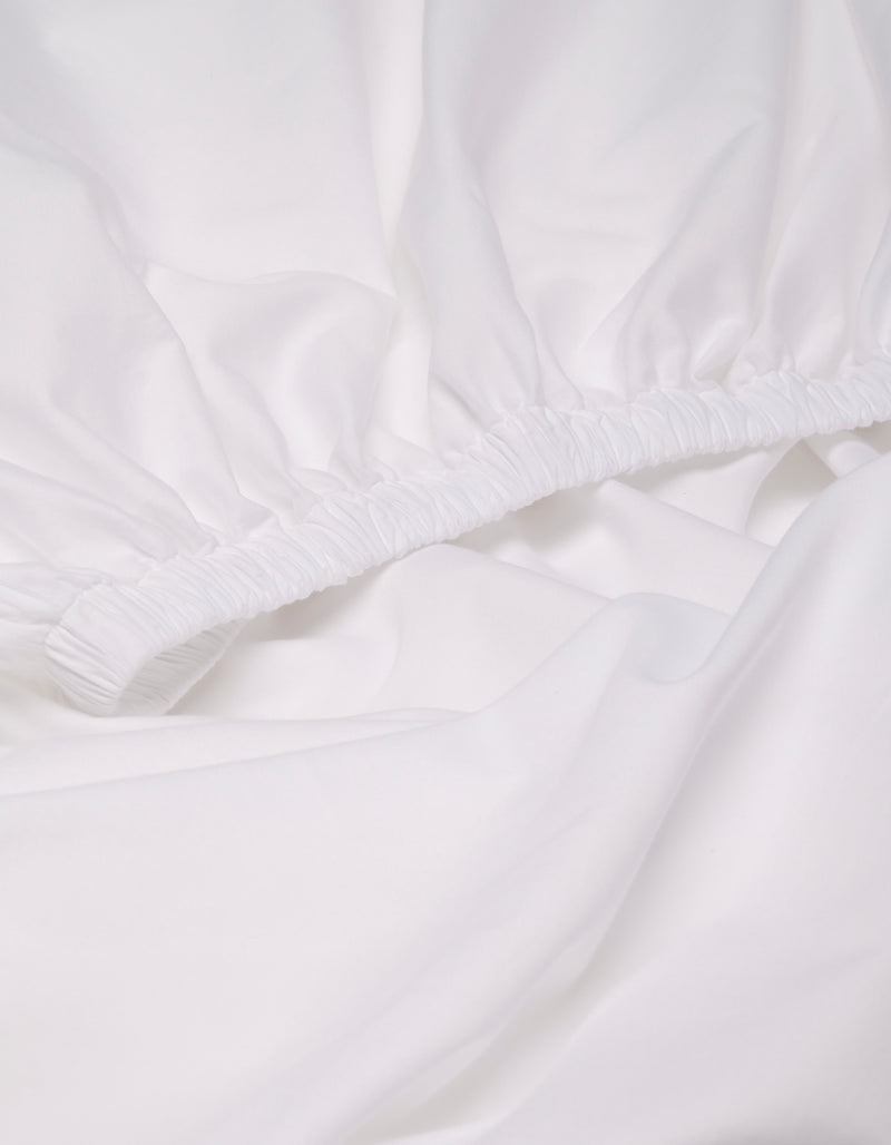 Close-up of the Cozy Earth Soft-Wash Cotton Fitted Sheet, featuring elastic edges, gathered fabric, and a smooth surface.