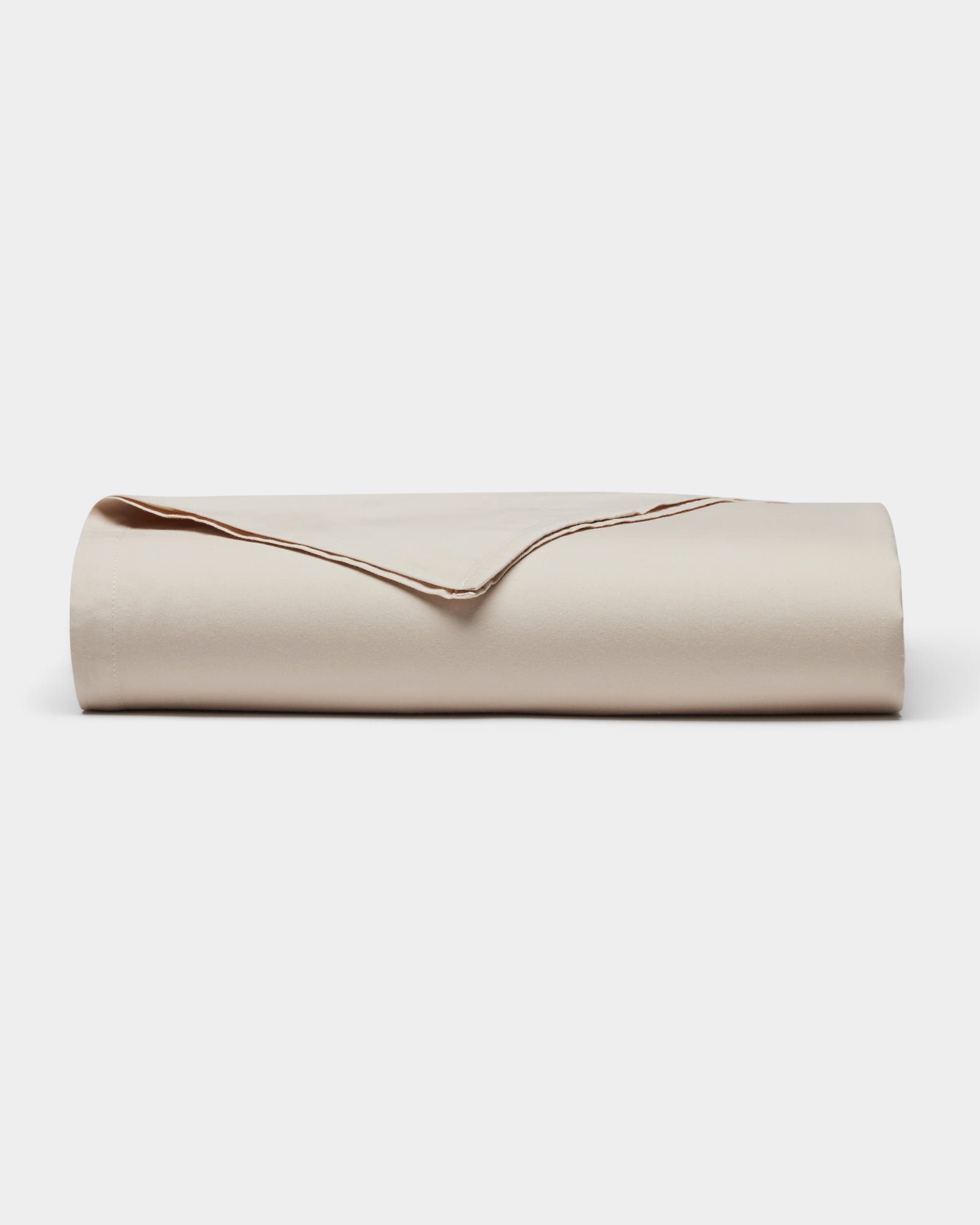 The Cozy Earth Soft-Wash Cotton Flat Sheet, neatly folded with one corner turned over to display its smooth texture and edges, is shown against a plain white background.