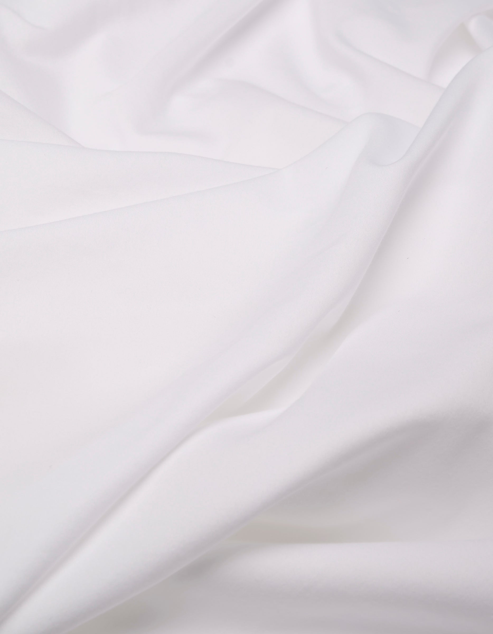 A close-up of the Cozy Earth Soft-Wash Cotton Duvet Bundle shows its soft, white fabric with gentle folds and a smooth texture, creating a calm and clean appearance.