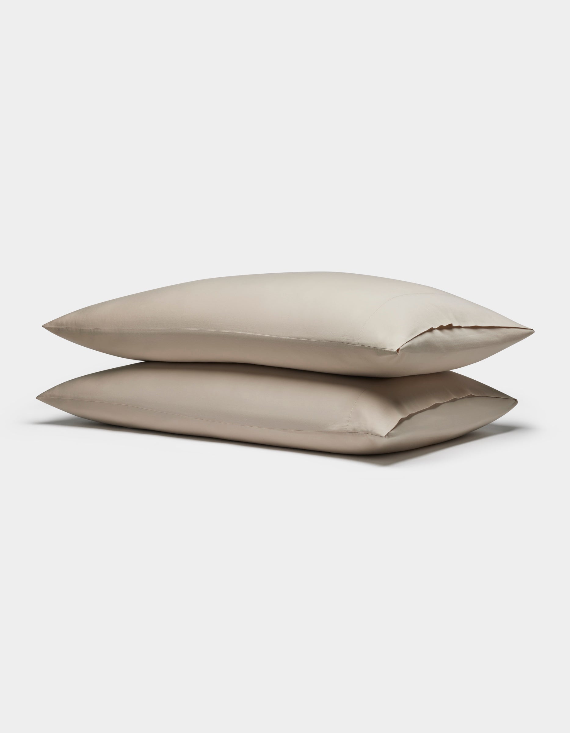 Two Soft-Wash Cotton Pillowcases by Cozy Earth are stacked together against a plain white background.|Color:Driftwood